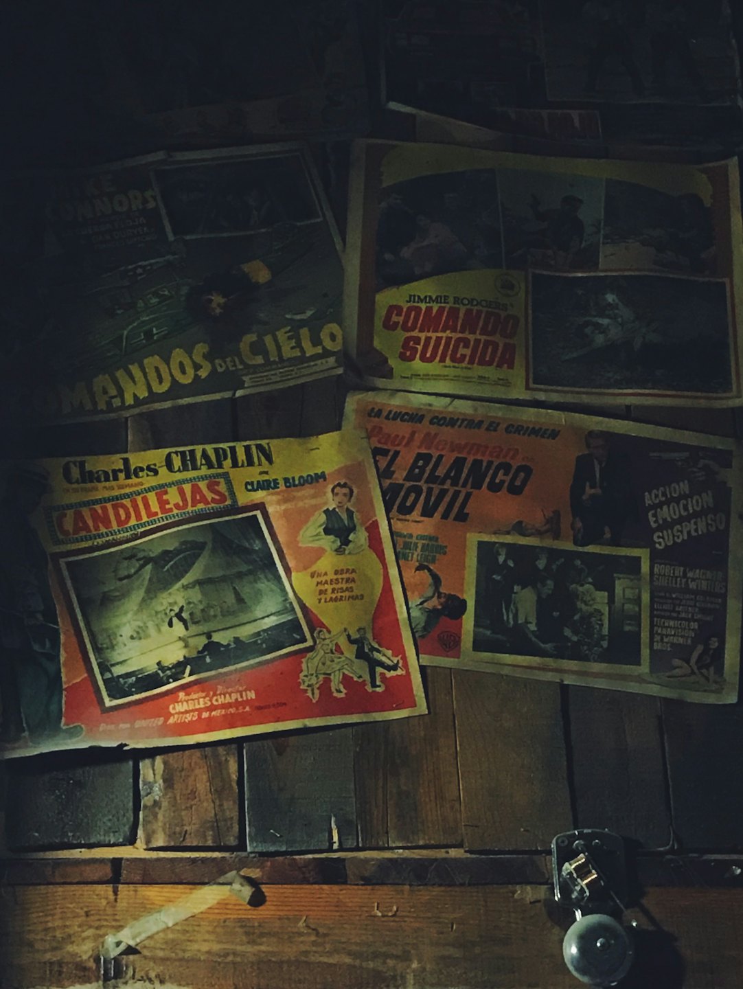 Vintage Spanish movie posters scattered on a wooden table.