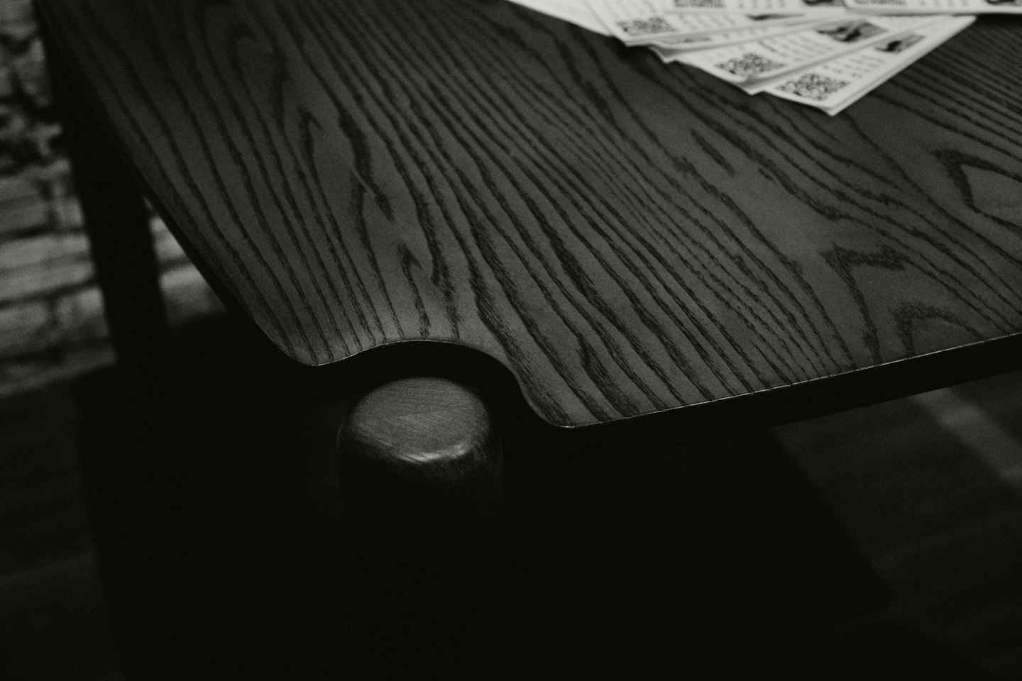 A stack of white cards with QR codes rests on a wooden table.